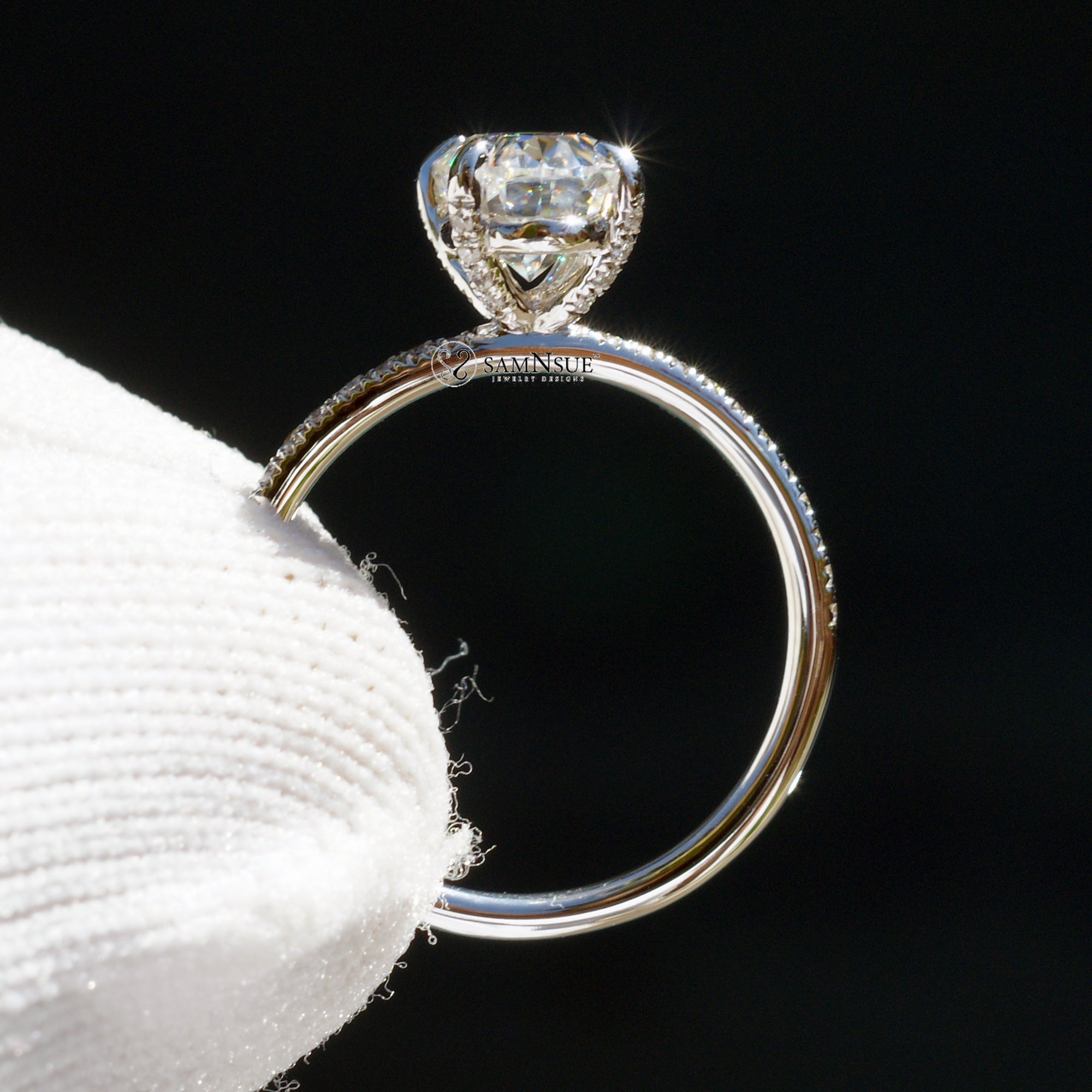 Solitaire oval moissanite ring with diamonds on the band and prongs in white gold