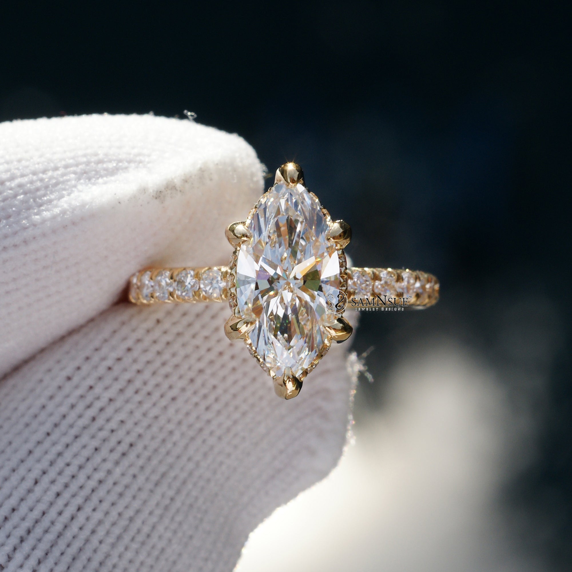 Marquise cut diamond engagement ring with drenched prongs hidden halo and rounded diamond band in yellow gold