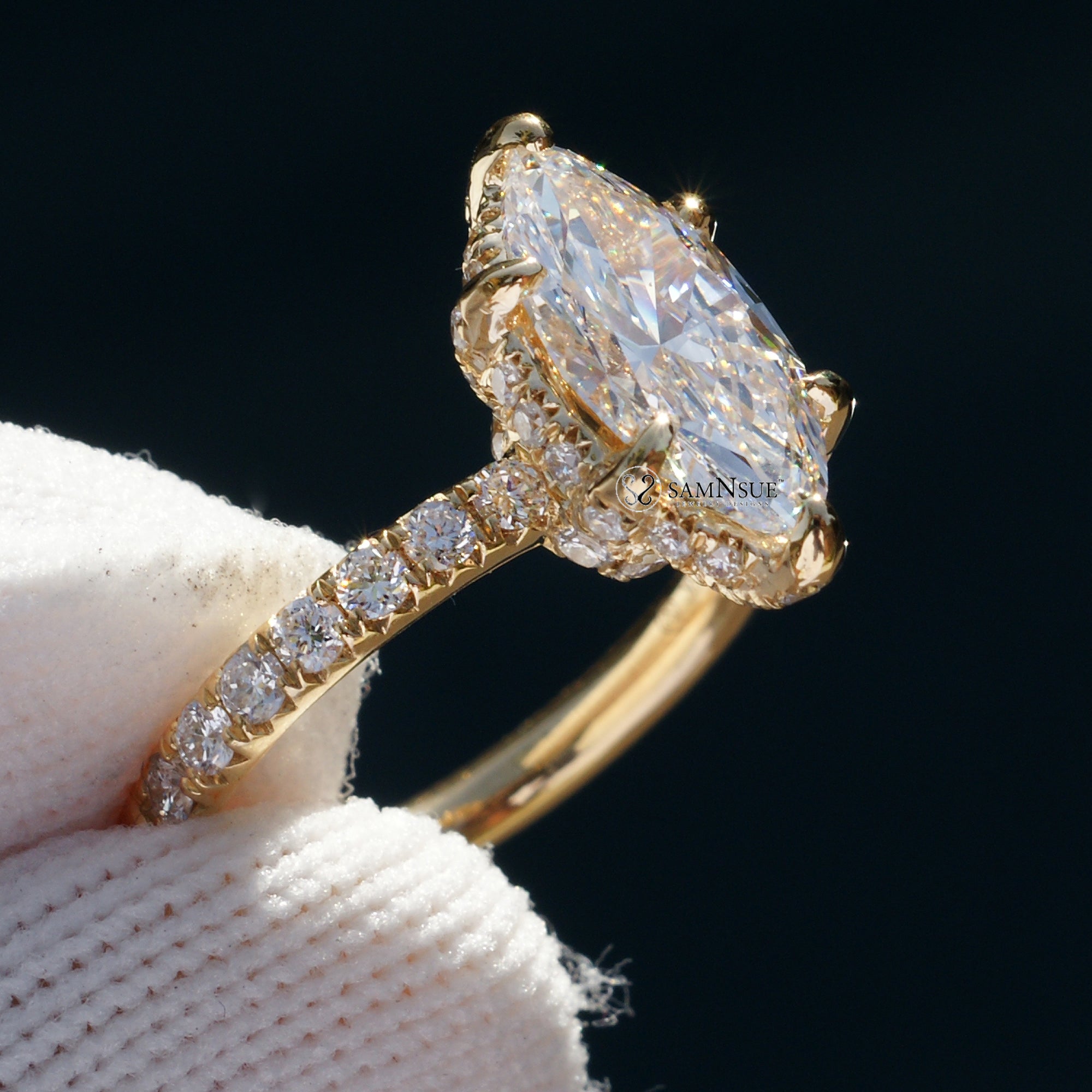 Marquise cut diamond engagement ring with drenched prongs hidden halo and rounded diamond band in yellow gold