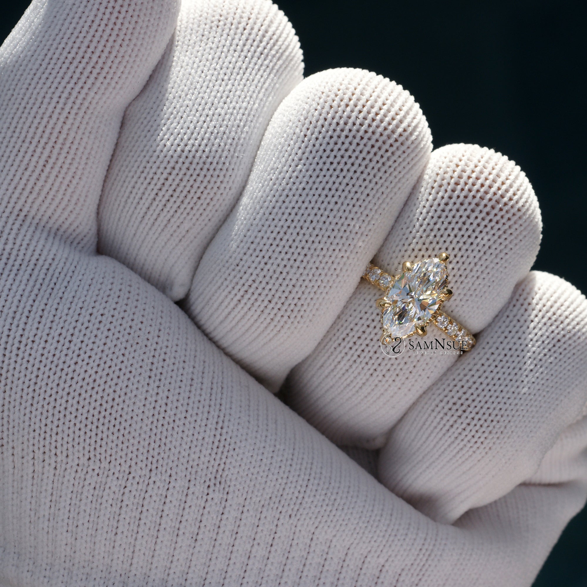 Marquise cut diamond engagement ring with drenched prongs hidden halo and rounded diamond band in yellow gold