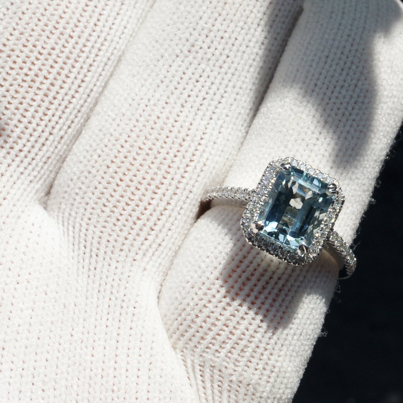 Emerald cut aquamarine engagement ring with diamond halo in white gold