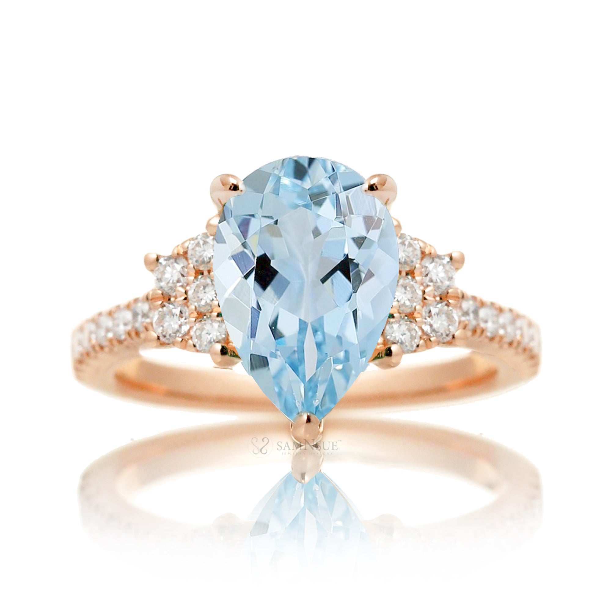 Pear aquamarine with diamond accent on the band and trapezoid shape side stones rose gold