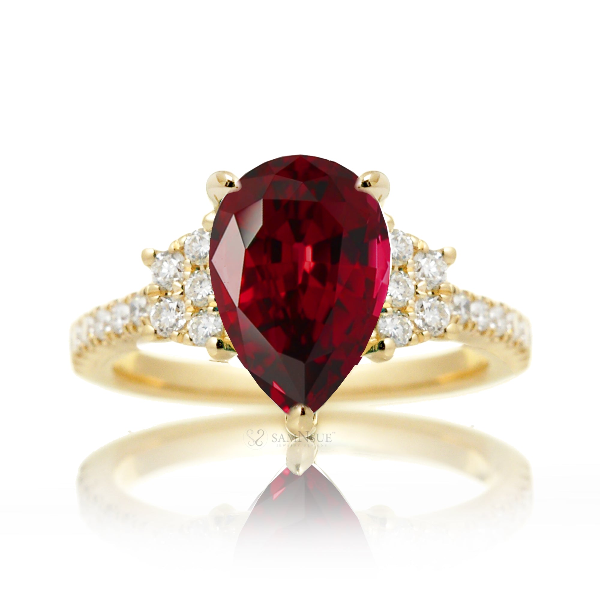 Pear cut ruby ring with trapezoid diamond side shape and band in yellow gold