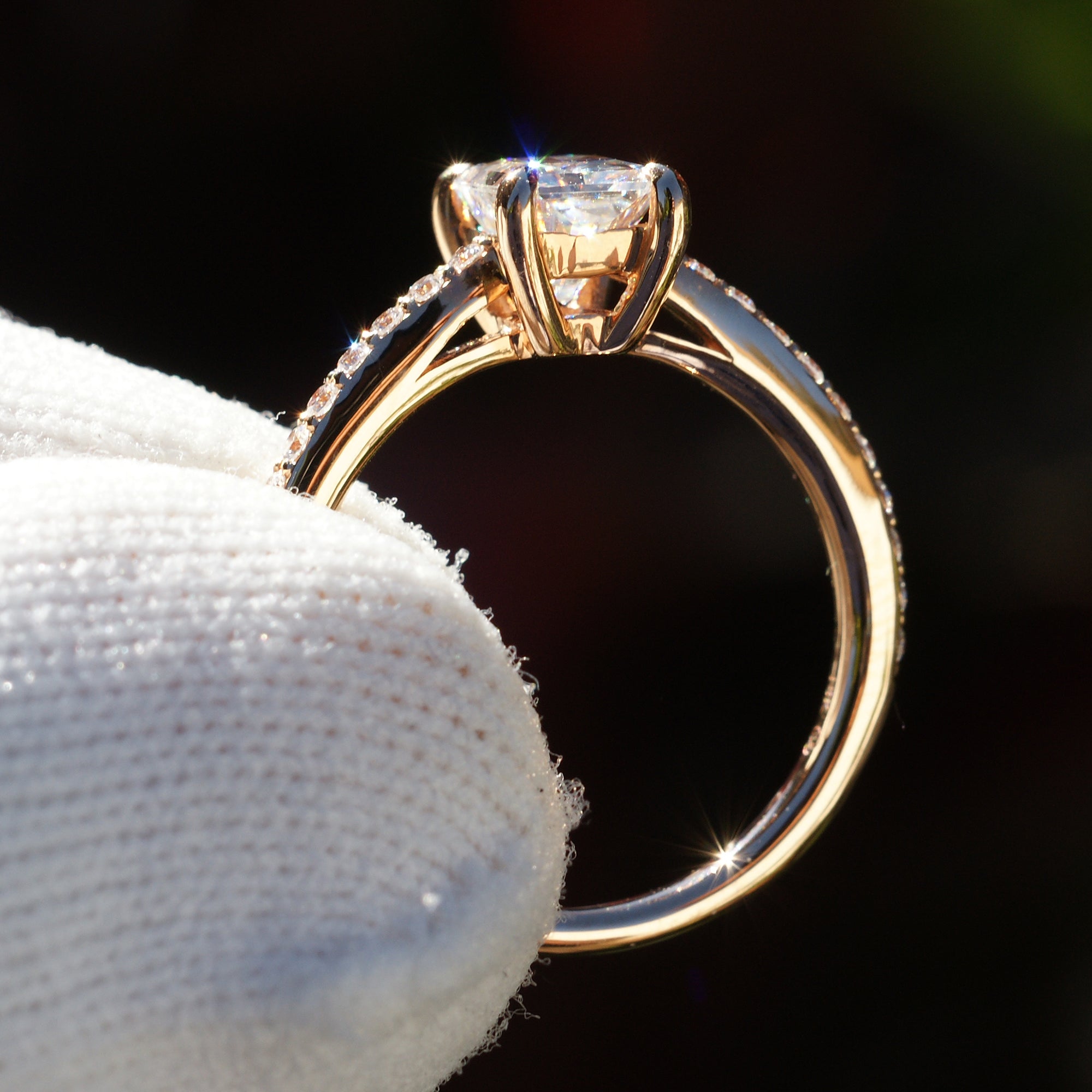 Radiant cut moissanite ring in rose gold with diamond accent on band, side profile