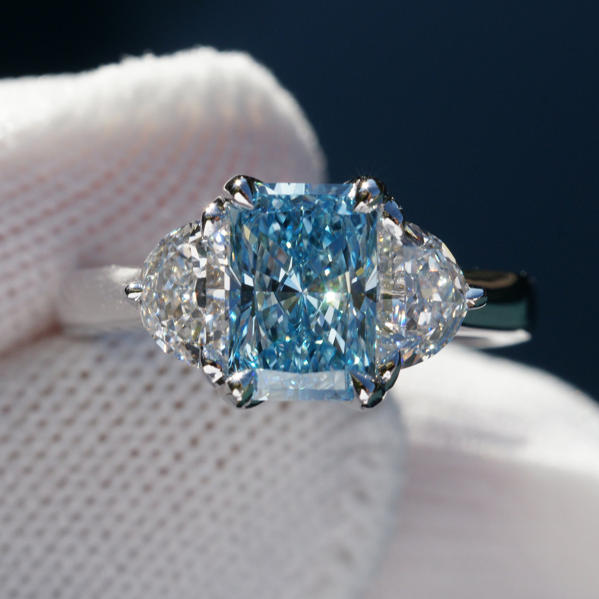 Rare fancy blue radiant cut diamond half moon three stone ring