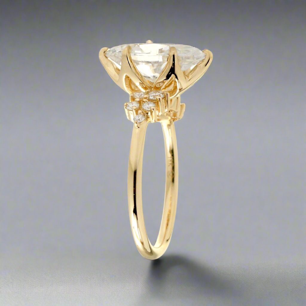 Marquise cut moissanite crown basket and diamond side stone ring yellow gold