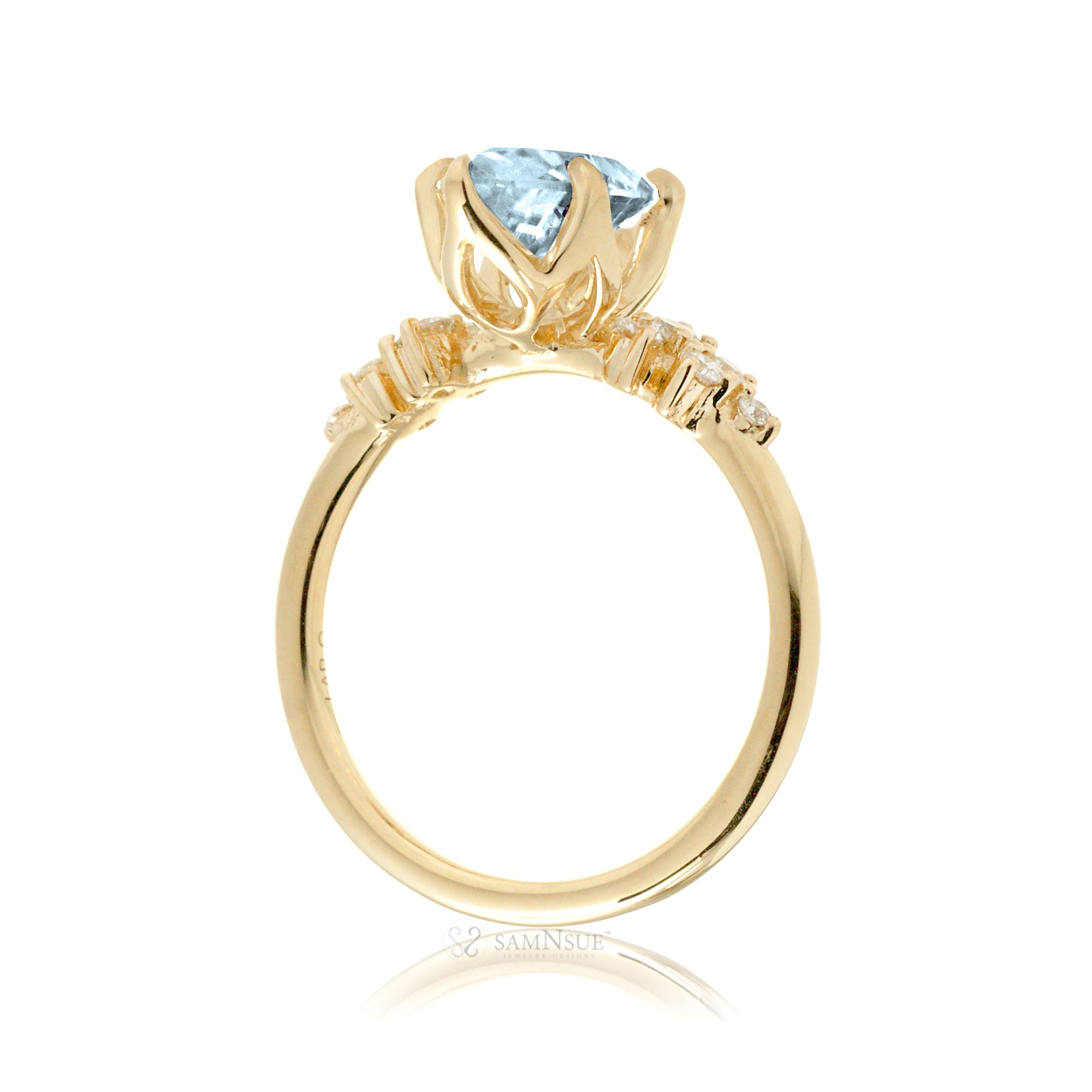 Aquamarine ring with oval center stone and side accent diamonds in yellow gold