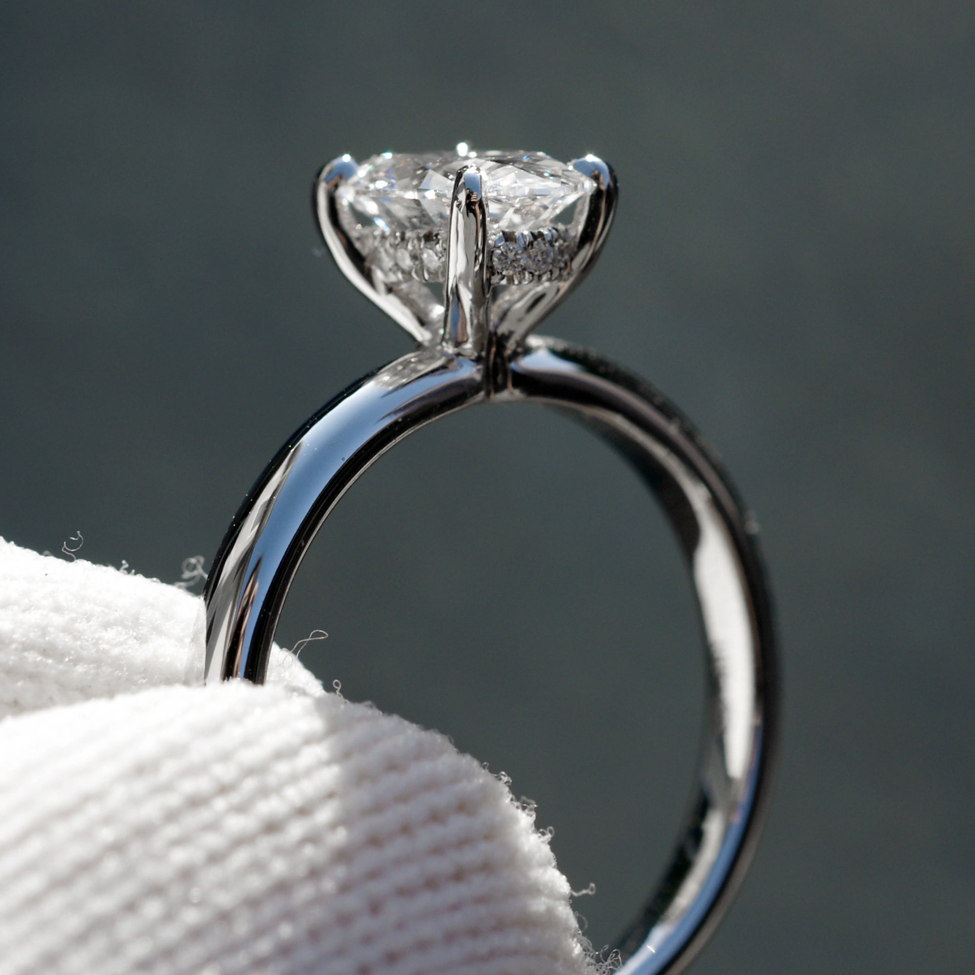 Oval solitaire diamond engagement ring with a hidden halo in white gold