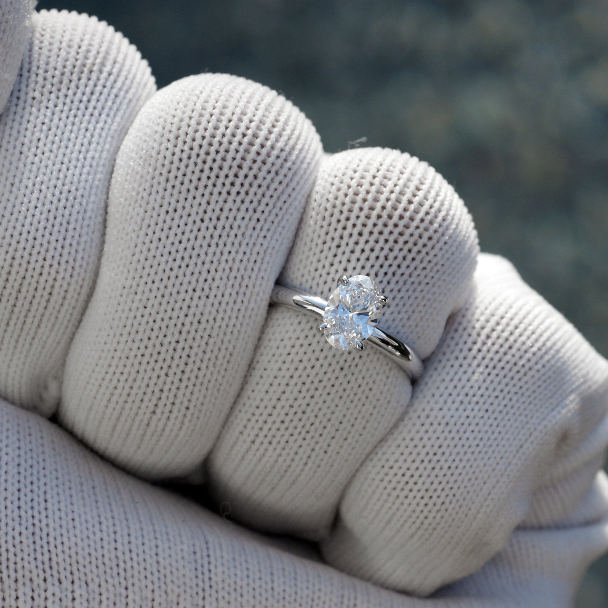 Oval solitaire diamond engagement ring with a hidden halo in white gold