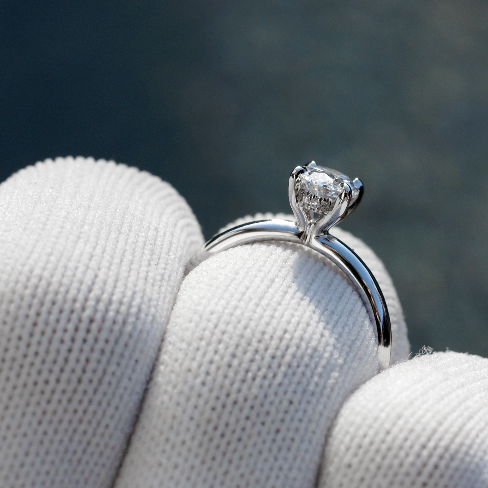 Oval solitaire diamond engagement ring with a hidden halo in white gold