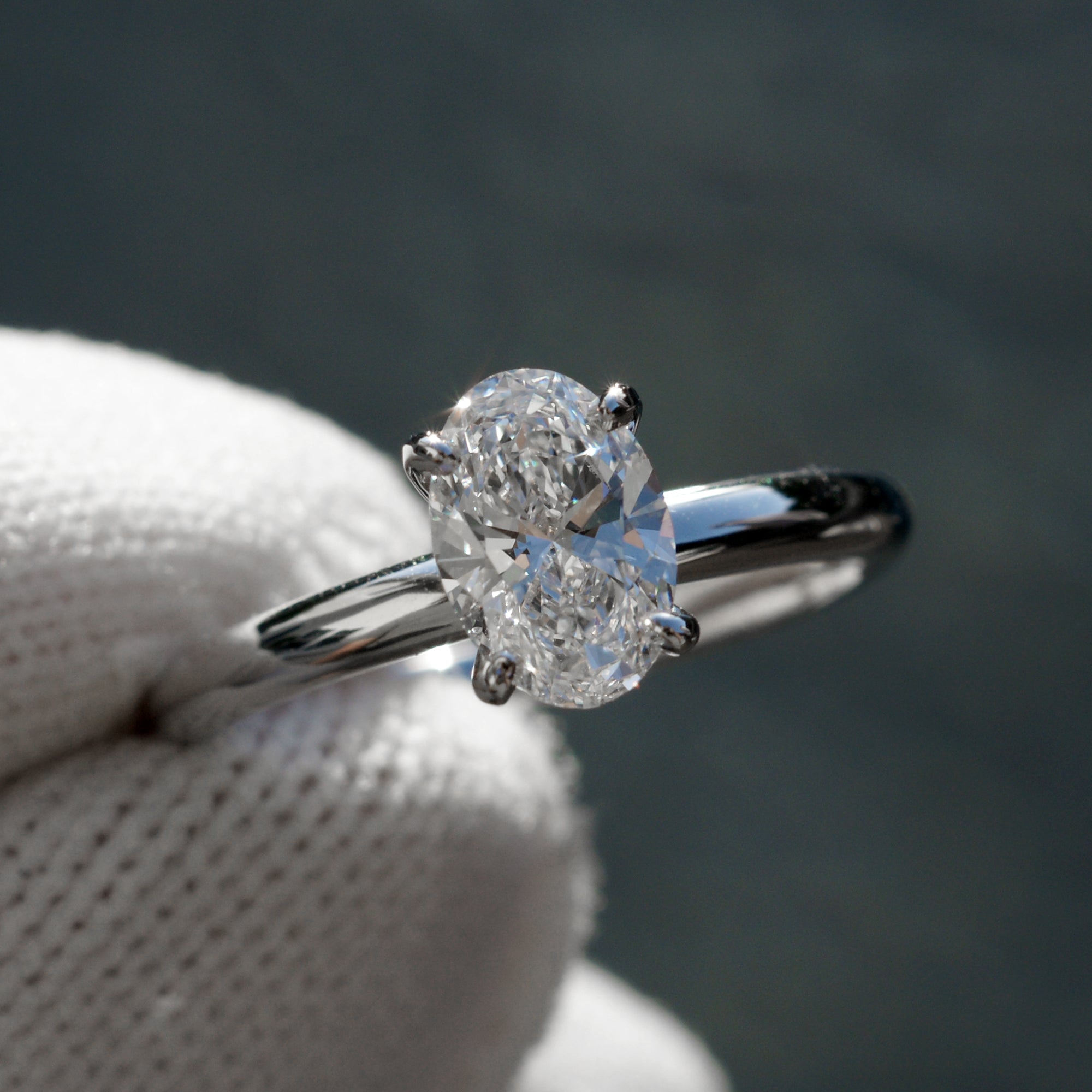 Oval solitaire diamond engagement ring with a hidden halo in white gold