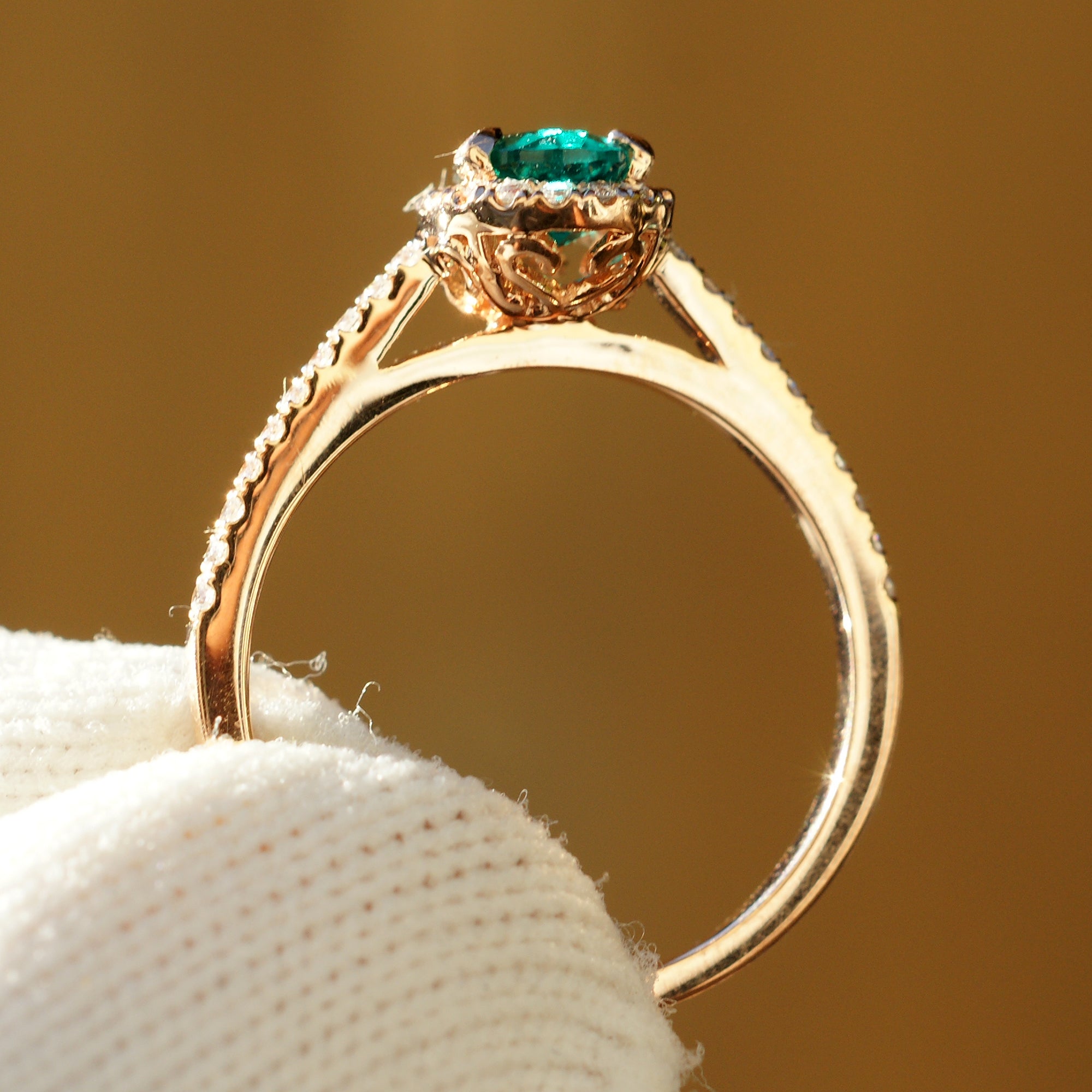 Pear cut emerald diamond halo engagement ring with the signature 8x5mm rose gold