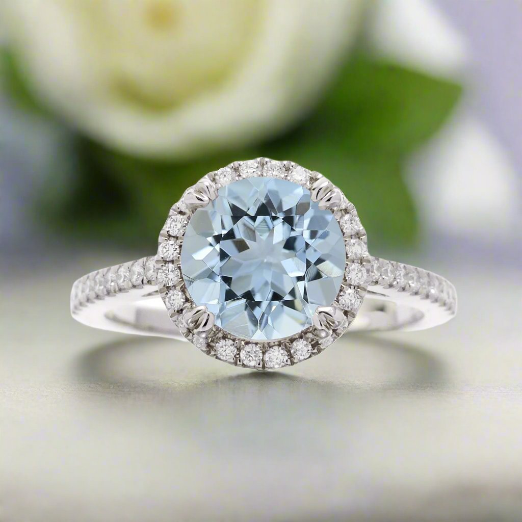 Round aquamarine ring with a diamond halo and cathedral white gold setting