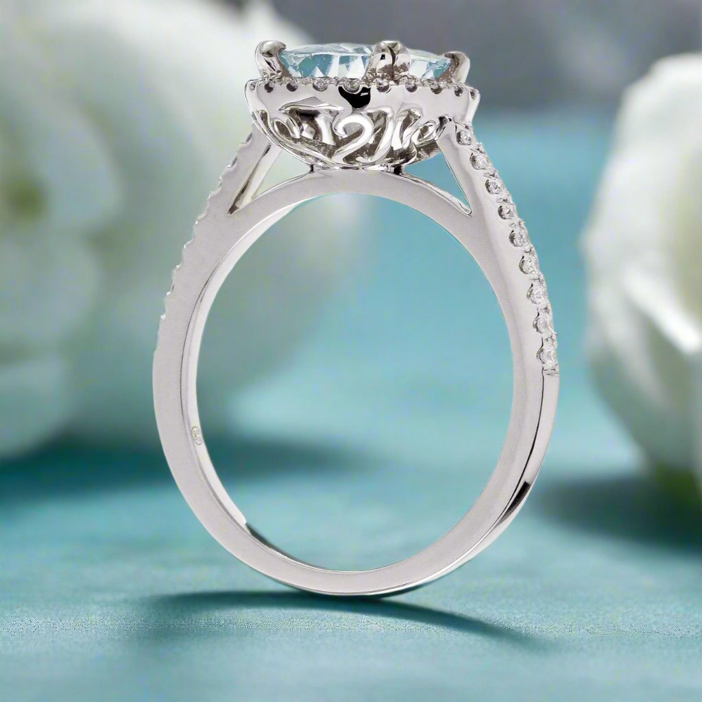 Round aquamarine ring with a diamond halo and cathedral white gold setting