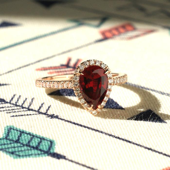 Pear ruby engagement ring with a diamond halo