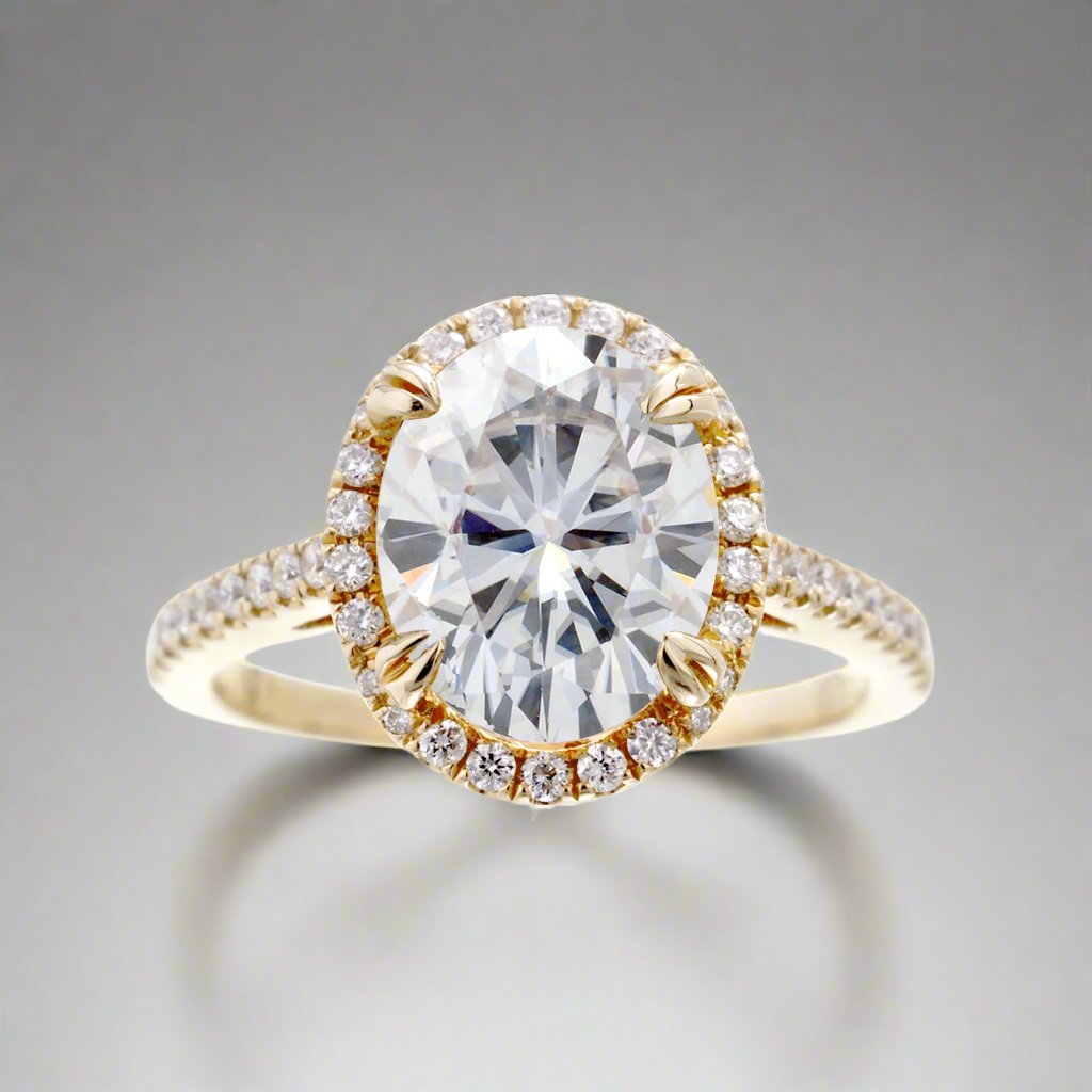 Oval cut moissanite engagement ring with a diamond halo in yellow gold