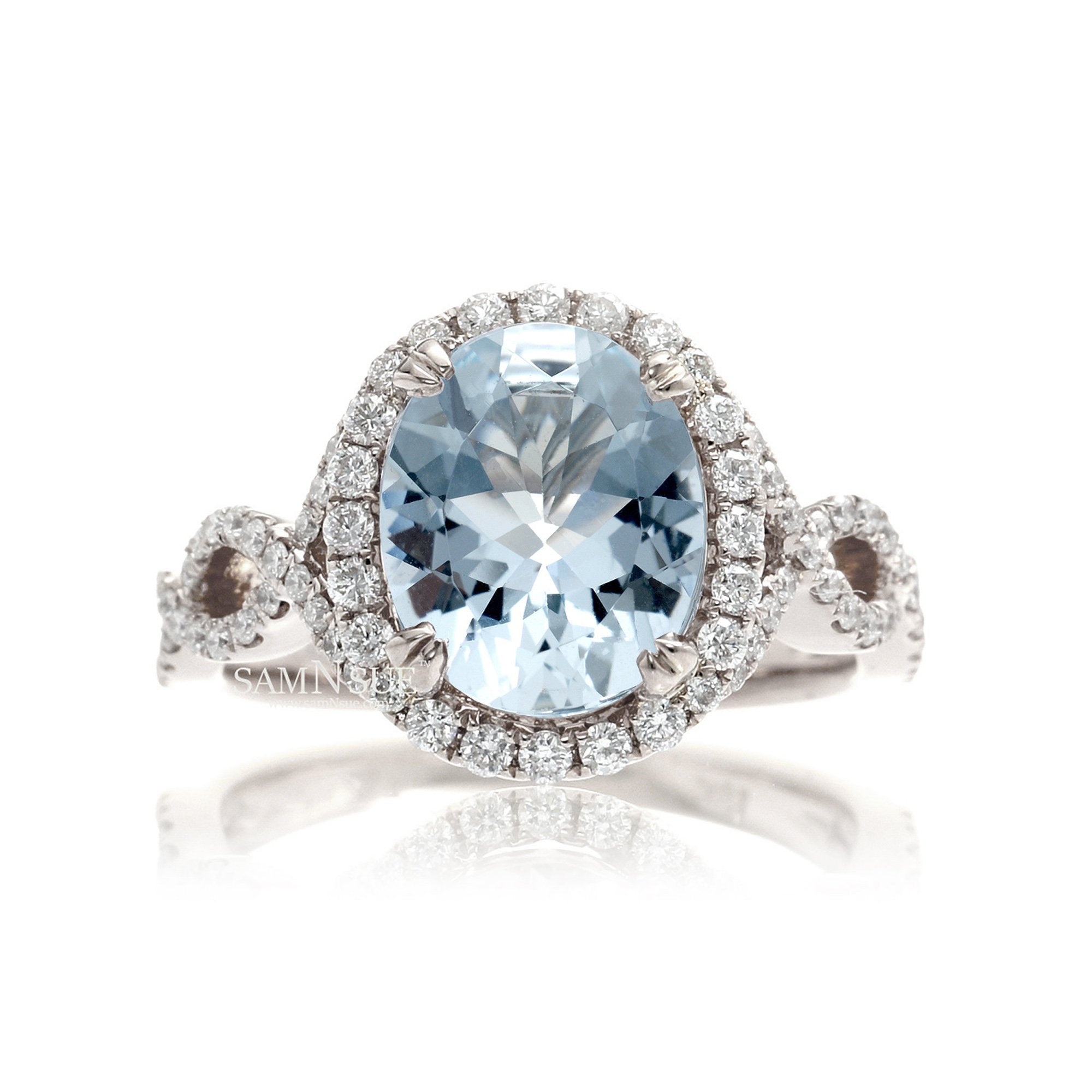 Oval cut aquamarine with diamond halo and twisted band white gold