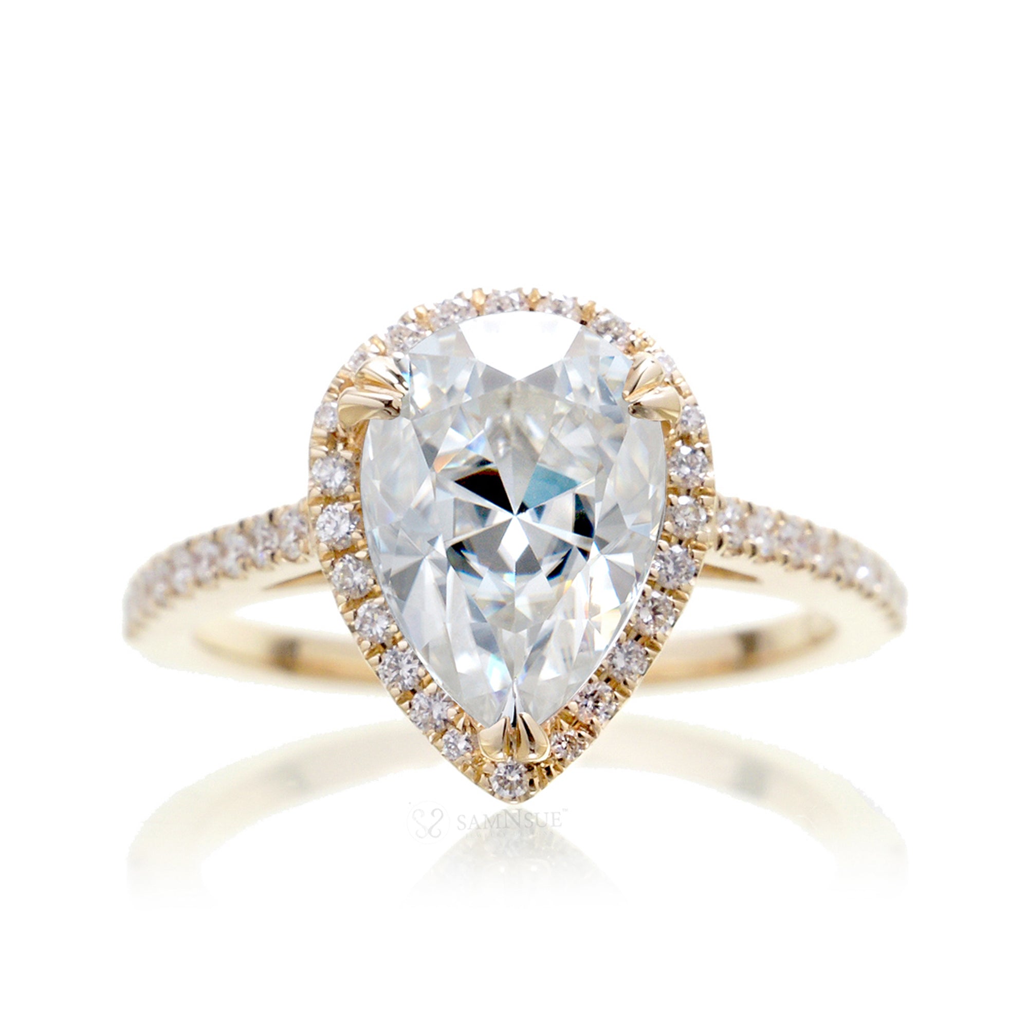 Pear moissanite and diamond halo ring in the signature yellow gold