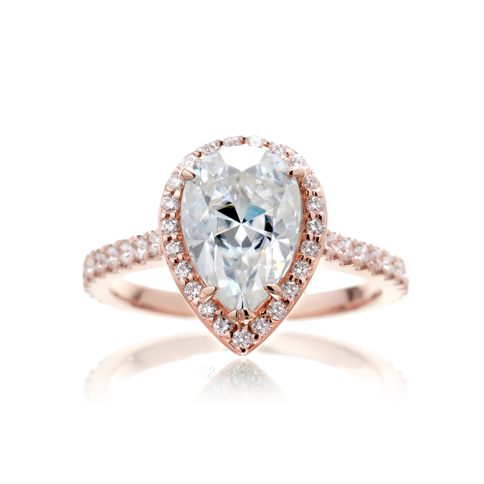 Pear moissanite engagement ring with a diamond halo in the sunset rose gold