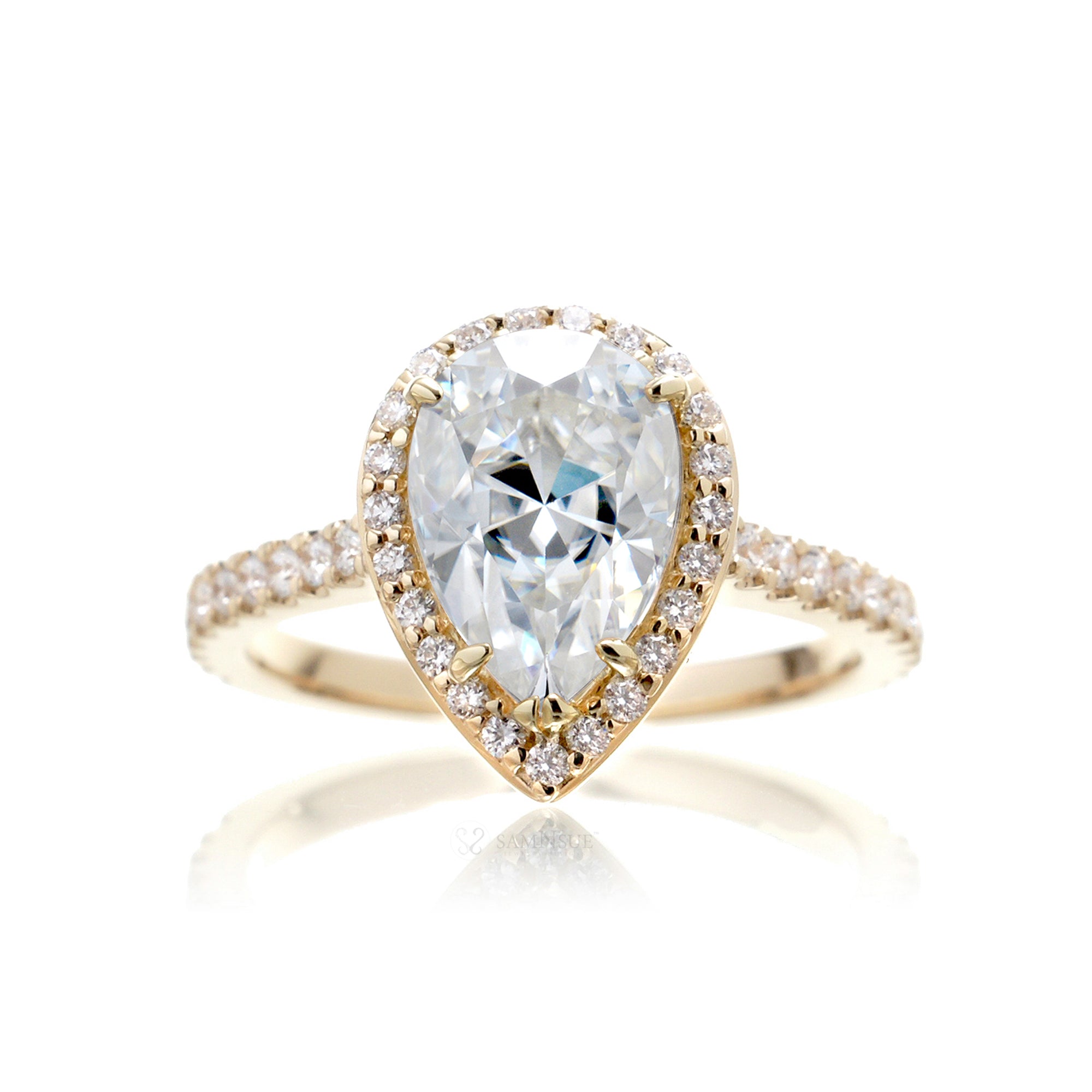 Pear moissanite engagement ring with a diamond halo in the sunset yellow gold